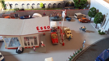 Station essence Esso avec une 404 qui fait le plein de super, ainsi qu'une 403 et sa caravane Eriba.